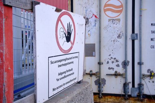 Entrance to industrial port area with posted warning and instruction signs.